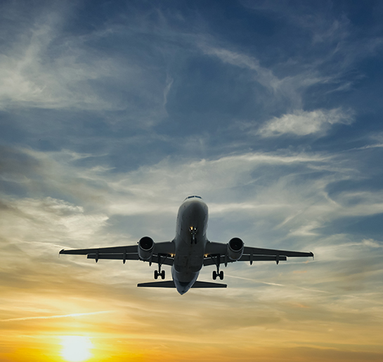 The plane against the blue sunset sky. The setting sun. Sunset.